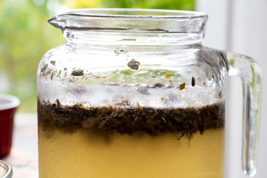 Iced yerba mate in glass jar with herbs - by circleofdrink